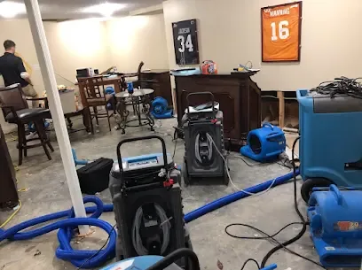 Air movers and a dehumidifier set up across a finished lower-level room